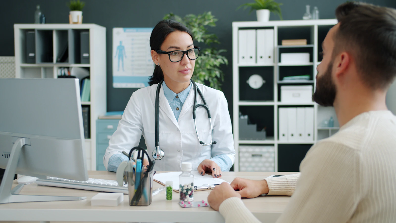 Doctor discussing care with a patient and recording clinical information
