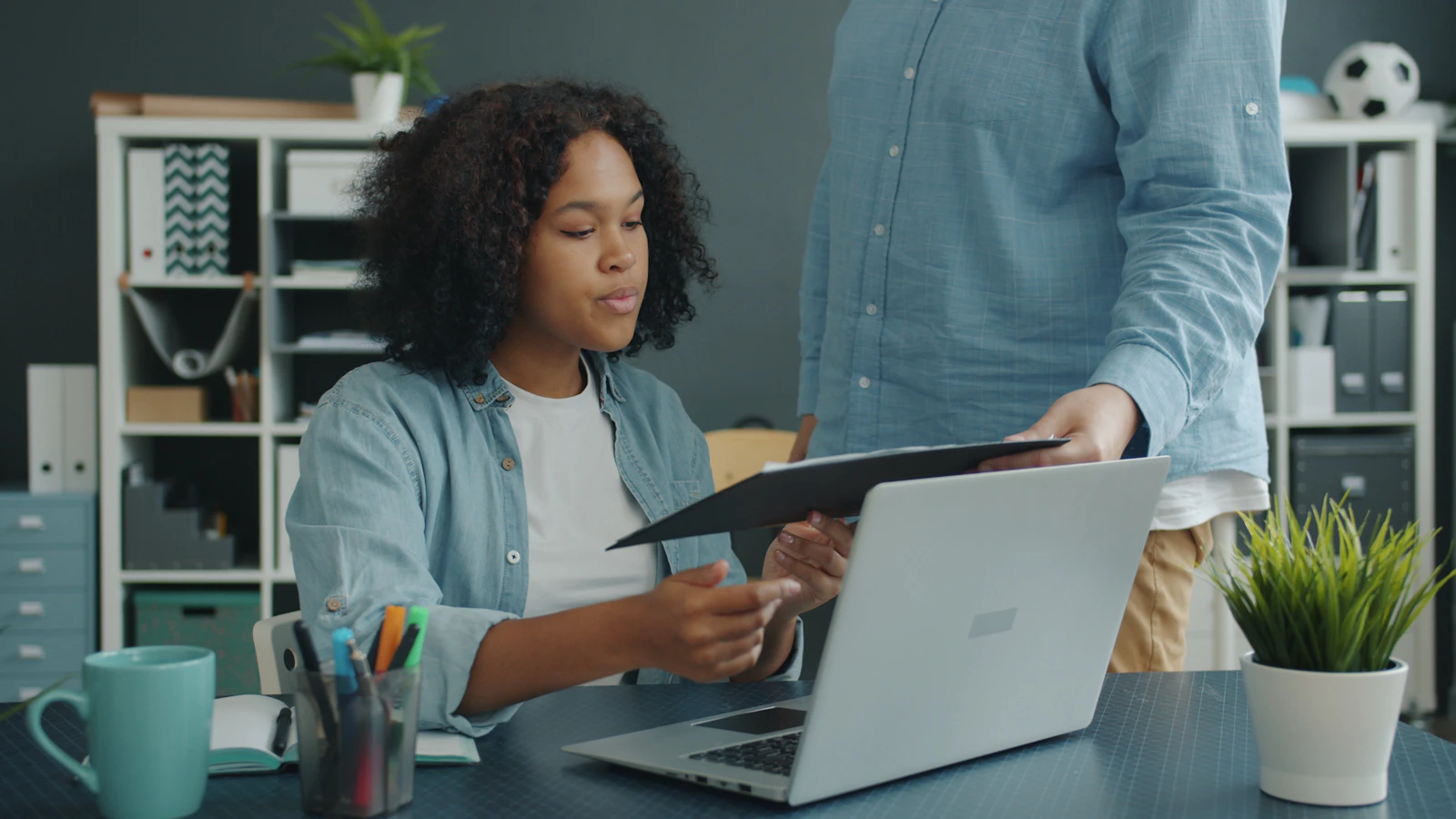 Colleagues reviewing documents and working at a laptop